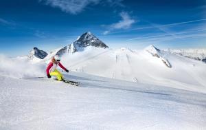 图克斯Hotel Pinzger Tux的一个人在雪覆盖的山里滑雪
