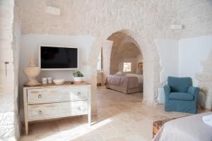 阿尔贝罗贝洛Chiancole - Trulli Experience的客厅配有电视和蓝椅