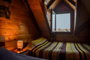 乌尔齐尼Sojenica Ivona的小木屋内的卧室,配有床和窗户