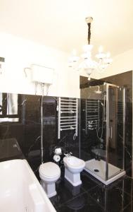 安科纳AN Deluxe Suites的一间带卫生间、水槽和吊灯的浴室