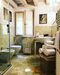 索阿韦Locanda Lo Scudo的一间带两个盥洗盆、浴缸和卫生间的浴室