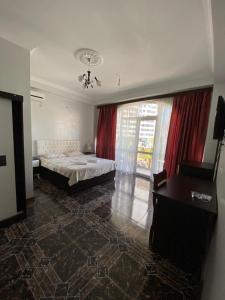 巴统优雷夏酒店的一间卧室配有一张床、一张书桌和一个窗户。
