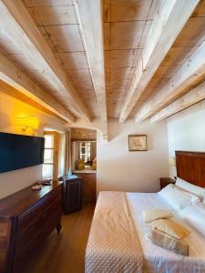 索阿韦Locanda Lo Scudo的一间卧室设有一张大床和木制天花板
