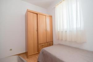 苏佩塔尔Apartments Batinic的一间卧室配有一张床和一个木制橱柜