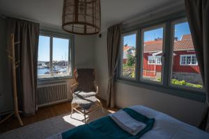 莫勒松德Mollösunds Wärdshus的一间卧室配有床、窗户和椅子