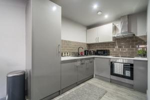 哈德斯菲尔德Hotl Aparts Huddersfield Central的厨房配有白色橱柜和不锈钢用具