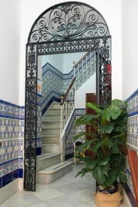 加的斯Hostal Colón的一道楼梯,门在一栋蓝色和白色瓷砖的房子里