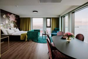 斯沃尔韦尔Thon Hotel Svolvær的酒店客房带一张床、一张桌子和椅子