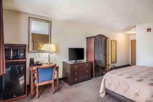 Eldridge埃尔德里奇北达文波特品质酒店的酒店客房配有一张床、一张书桌和一台电视。