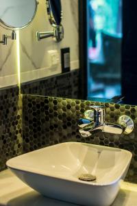 亚松森Five Hotel & Residences的浴室设有白色水槽和镜子