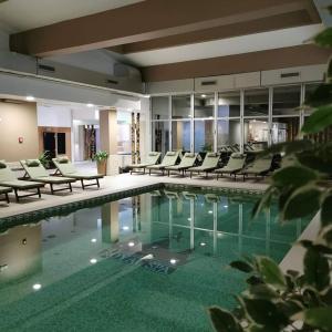 巴尼亚科维利亚查皇家Spa酒店的一座配有桌椅的酒店游泳池