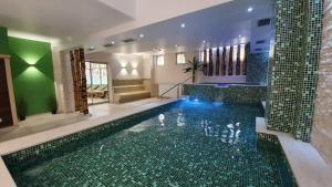 巴尼亚科维利亚查皇家Spa酒店的房屋中间的游泳池