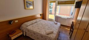 菲纳莱利古雷科利布瑞酒店的一间小卧室,配有床和窗户