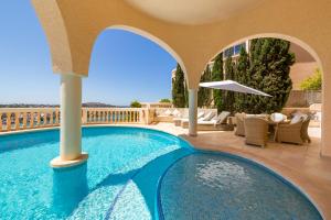 圣蓬萨Meerblick Villa "Buena Vista" in Santa Ponsa, Mallorca的阳台的游泳池配有椅子和遮阳伞