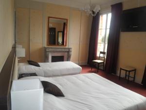 Cléry-Saint-AndréLogis Hotels Restaurants- Villa des Bordes的酒店客房设有三张床和壁炉