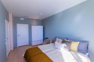 RingsakerMjøssuite with lovely view的一间卧室设有一张床和蓝色的墙壁