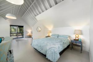 Te HoroThe Apartment - The Lodge Te Horo的白色卧室配有床和椅子
