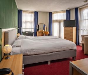 贝德姆市政厅酒店的一间卧室配有一张大床和电视