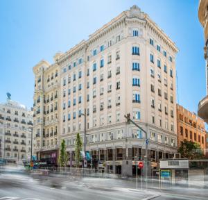 马德里Hotel Madrid Gran Via 25, Affiliated by Meliá的街道拐角处的白色大建筑
