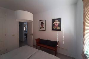 卡门港El Pasadizo - The secret passage-Puerto del Carmen的一间卧室配有一张床和一把椅子,墙上挂着图片