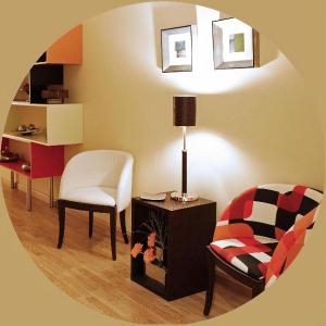 AutolHostal San Isidro的客厅配有椅子和带台灯的桌子