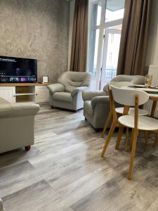 敖德萨Апартаменты Ясная Поляна的客厅配有电视和桌椅