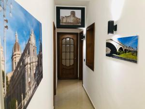 卡塔尼亚La casa di Palma的走廊上设有门,墙上挂有图片