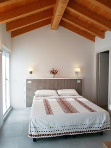 莱科sweet homes的白色卧室设有一张带木制天花板的大床