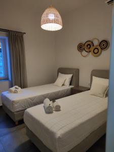 阿波罗尼亚Villa Ageri的配有吊灯的酒店客房内的两张床