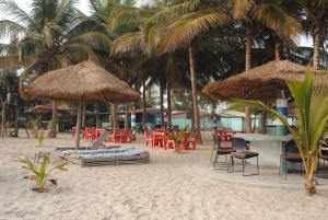 SanyangRainbow beach resort的海滩上带桌椅和遮阳伞的海滩