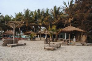 SanyangRainbow beach resort的海滩上设有椅子和遮阳伞,棕榈树