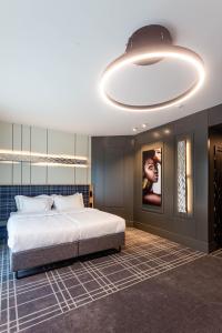 布雷斯特Бутик-отель Status的一间卧室配有一张大床和一个大型灯具