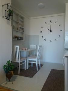 鲁马Apartman Breza的一间设有两把椅子和墙上一个时钟的房间