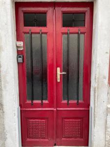 皮兰Apartment Petka的大楼上带黑色栏杆的红色门