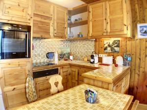 夏蒙尼-勃朗峰Ladybird Inn的厨房配有木制橱柜和台面