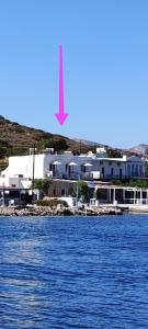 卡利诺岛Afrodite Luxury Rooms的水体旁的白色大建筑