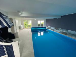 维滕贝克Ferienwohnung im Poolhaus mit Ostseeblick的蓝色天花板房子内的游泳池