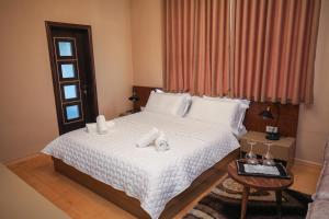 戈里察Vila 3 Korçë的一间卧室配有一张带白色床单的床和一扇窗户。