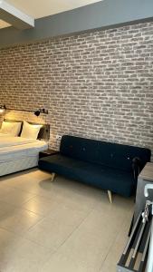 普罗夫迪夫Agora Studios的一间卧室设有一张床和砖墙