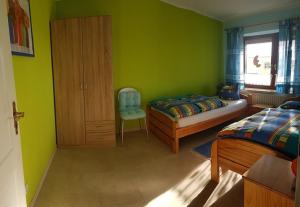 弗雷门Haus Christine的一间卧室设有绿色的墙壁、一张床和椅子