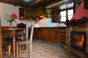 圣埃乌拉利亚德奥斯科斯Casa Freixe Apartamentos Rurales的厨房配有壁炉、桌子和炉灶。