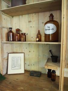 ZuidhornDe oude dokterspraktijk的一间设有木架、罐子和一张照片的房间