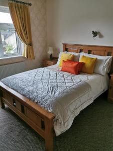 基拉尼Noraville House的一间卧室配有一张大床和四个枕头
