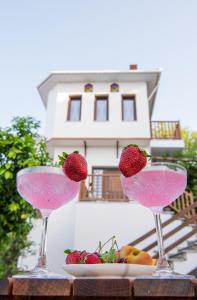 阿吉奥斯伊欧尼斯Aegean Blue - Villas Stivachtis的两杯装有草莓和一盘水果的玻璃杯