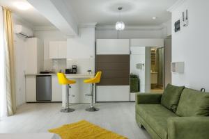 马马亚North Club Apartments II的客厅配有绿色沙发和黄色椅子