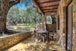 乌尔齐尼Stonehouse in Olives的一个带桌椅和石墙的庭院