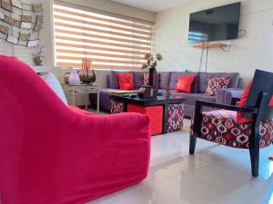 基多拉乌维拉住宿加早餐旅馆的客厅配有紫色沙发和红色枕头