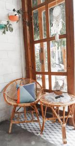 卡里蒙贾瓦KALINDA HOMEY的一张坐在桌子和窗户旁的藤椅