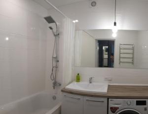 罗夫诺Чудова квартира в центрі міста的一间带水槽、浴缸和镜子的浴室