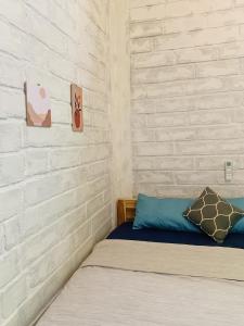 卡里蒙贾瓦KALINDA HOMEY的一间卧室设有一张床和砖墙